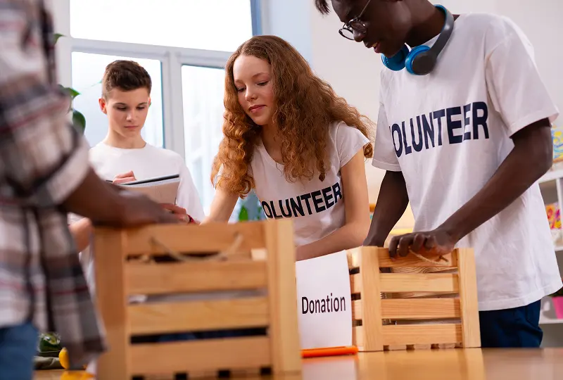 Volunteers sorting donation boxes together indoors.