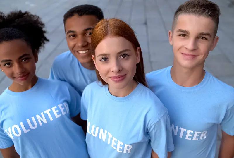 Group of young volunteers smiling together.
