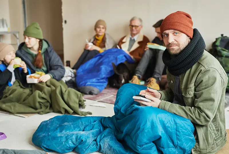 Group of people eating in shelter.