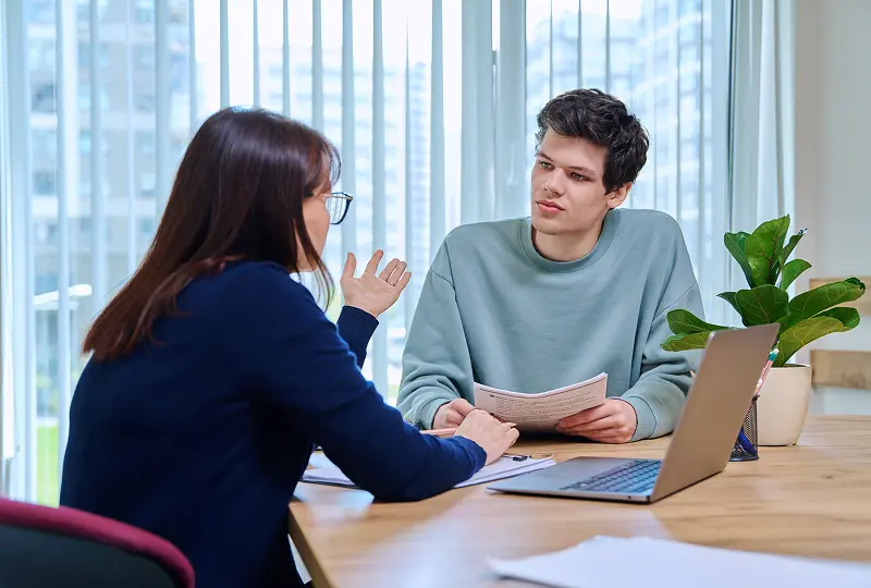 Two people discussing at a table.