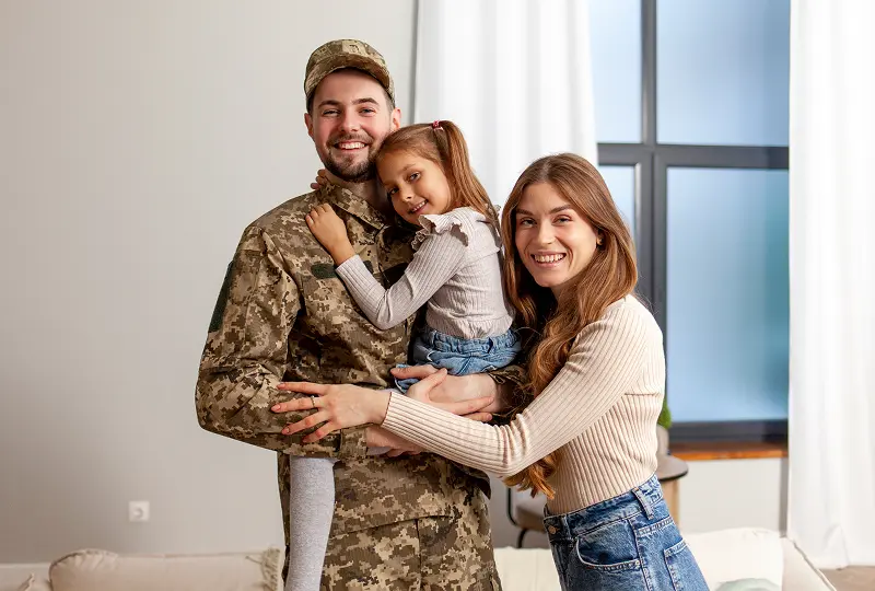 Happy family with soldier in camouflage uniform.